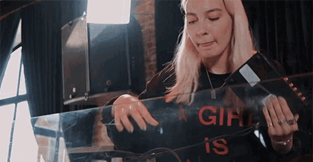 a woman wearing a shirt that says girl is playing a record player