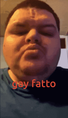 a close up of a man 's face with the word gay fatto written in red