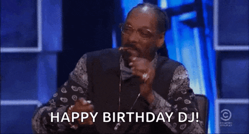 snoop dogg is smoking a cigarette and blowing smoke out of his mouth .