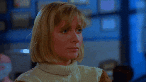 a woman wearing a white sweater is looking at something