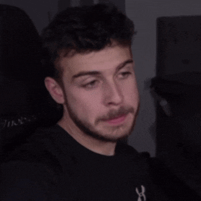 a man with a beard is wearing a black shirt with a white x on it