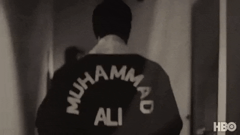 a black and white photo of a man wearing a jacket with the name muhammad ali on it .