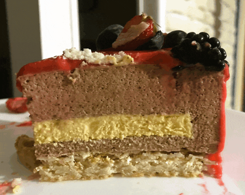 a slice of chocolate cake with berries on top on a white plate
