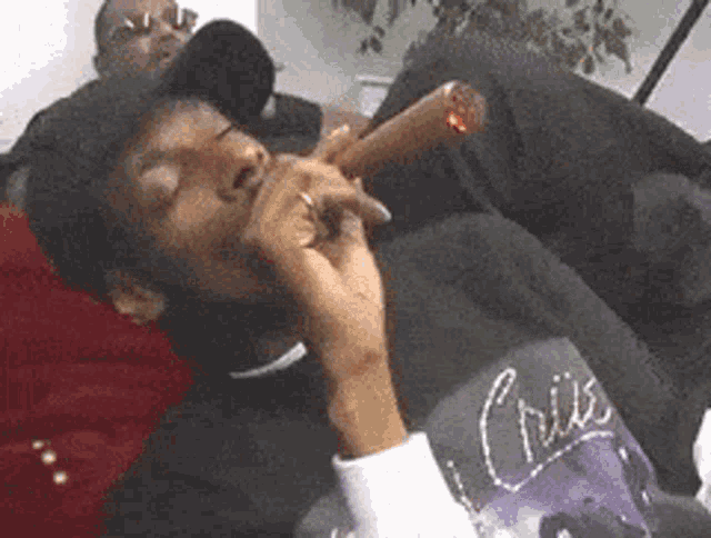 a man wearing a shirt that says crisis smoking a cigar