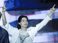 a man in a white shirt is giving a peace sign