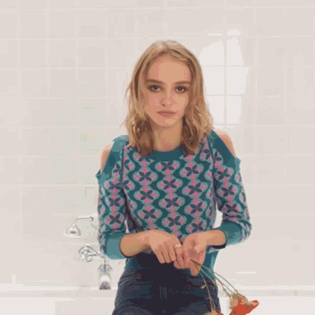 a woman in a sweater is dancing in a bathroom