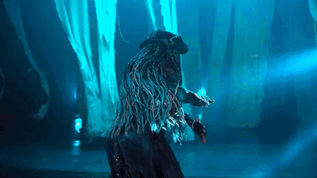 a person with dreadlocks in a dark room