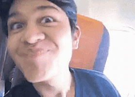 a close up of a person making a funny face on an airplane