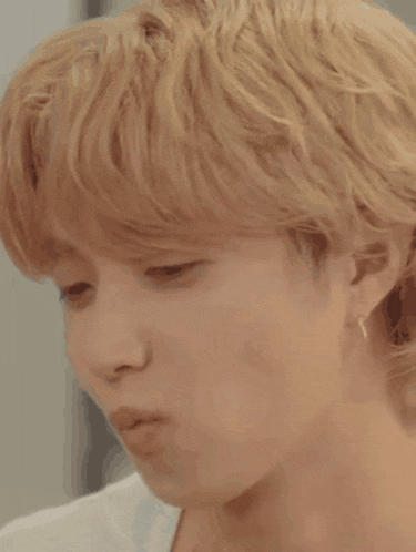a close up of a young man 's face with blonde hair .