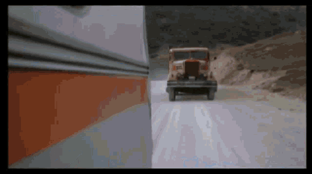 a truck is driving down a snow covered road next to a bus