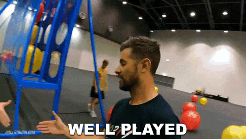 a man says well played in front of a blue basketball hoop