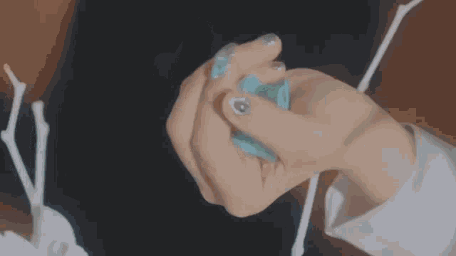 a close up of a person holding a blue ball in their hands .