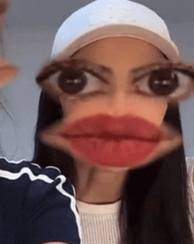 a woman wearing a hat and glasses is making a funny face with her mouth open .