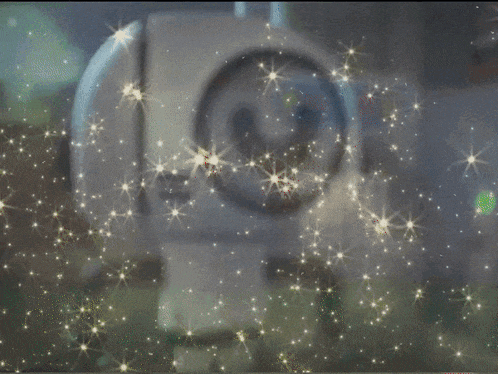 a blurred image of a robot with stars coming out of it 's eyes