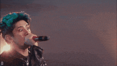 a man singing into a microphone with the letter d visible in the corner