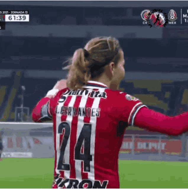 a female soccer player wearing a red and white jersey with the number 24 on the back