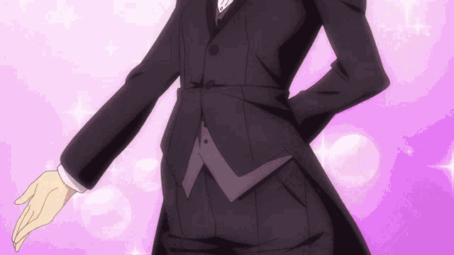 a man in a black tuxedo is standing in front of a pink background