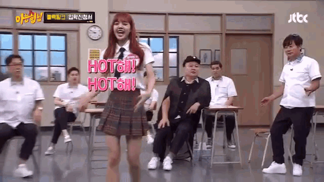 a girl in a school uniform is dancing in a classroom while a group of men sit at desks .