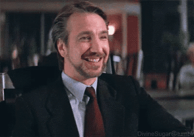 a man with a beard wearing a suit and tie is smiling .