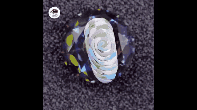 a nail with a colorful design on it is sitting on a diamond .