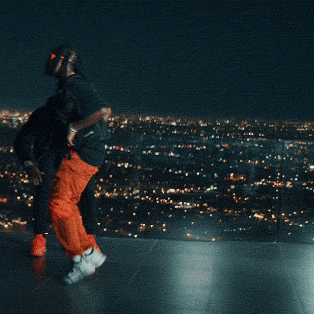 two men wearing sunglasses are dancing in front of a city skyline