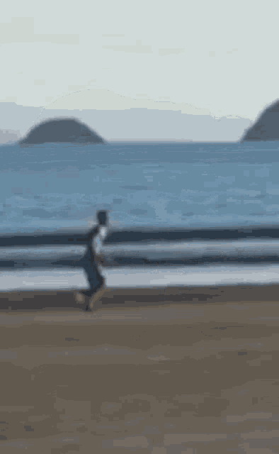 a blurry picture of a person running on the beach .