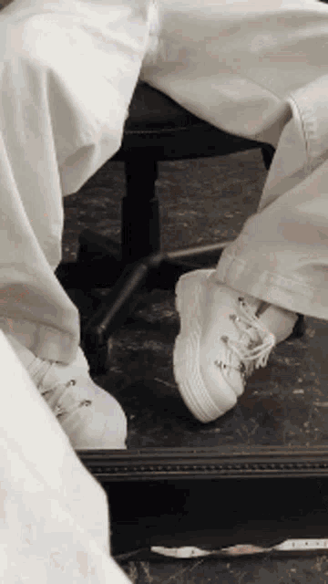 a person 's feet are visible in a mirror while wearing white shoes