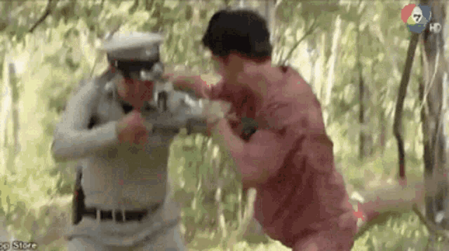 a man in a red shirt is fighting a man in a white hat