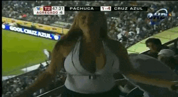 a woman is standing in front of a soccer field with a sign that says cruz azul