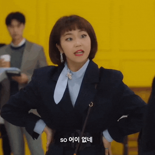 a woman in a suit and a blue shirt says so in a foreign language