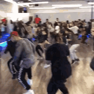 a large group of people are dancing in a dance studio