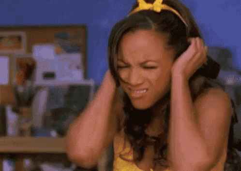 a woman with a yellow bow in her hair covering her ears with her hands