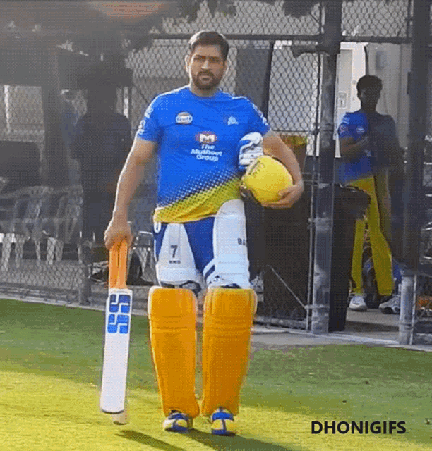 a man in a blue shirt with the number 7 on it holds a cricket bat