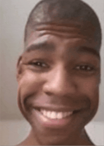 a close up of a man 's face with a funny face and a smile .