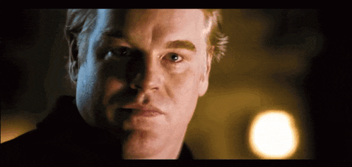 a close up of a man 's face with a yellow light behind him