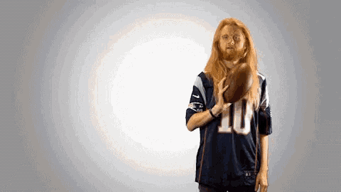 a man wearing a jersey with the number 10 on it holds a football