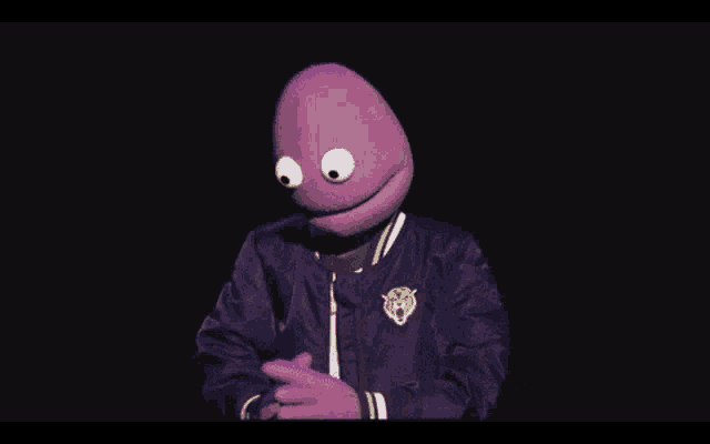 a purple puppet is wearing a purple jacket and smiling in front of the word good