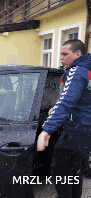 a man in a blue jacket is opening the door of his car