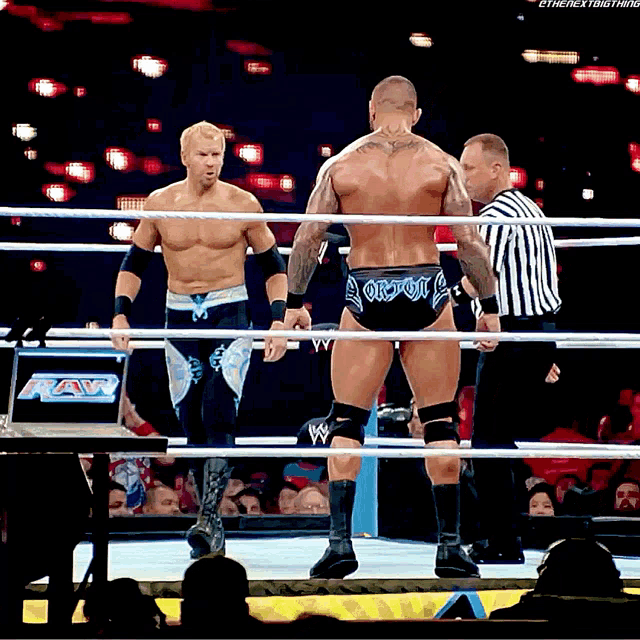 two wrestlers are in a wrestling ring and one of them is wearing a short that says ' aaron ' on it