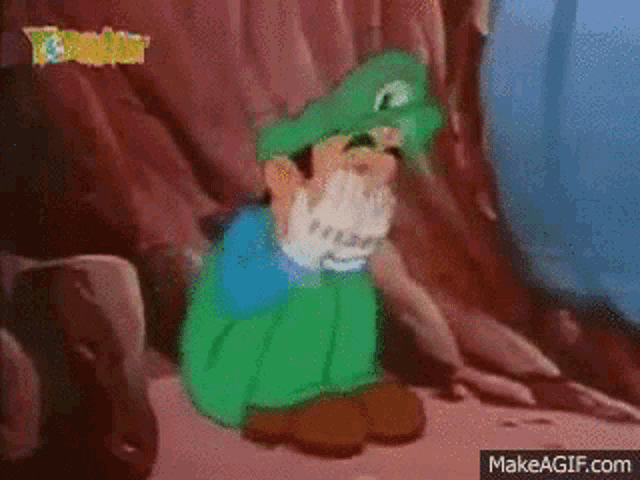 a cartoon character wearing a green hat and gloves is sitting on a rock .