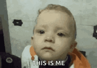 a baby is making a sad face and saying this is me .