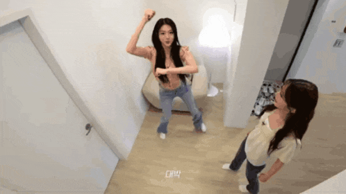 two women are dancing in a room with a sign that says ' oh ' on it