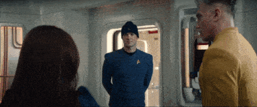 a man in a star trek uniform talks to a woman and another man
