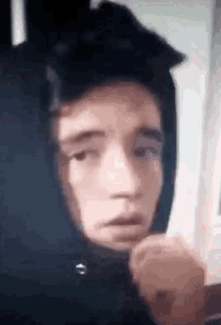 a close up of a person wearing a hoodie with a hood on their head .