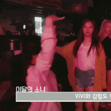a woman in a yellow cardigan is dancing with another woman in a white shirt