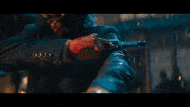 a man with horns is holding a gun in front of a fire