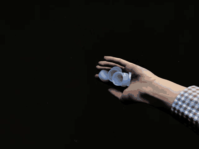a person 's hand is holding a bottle cap in their hand