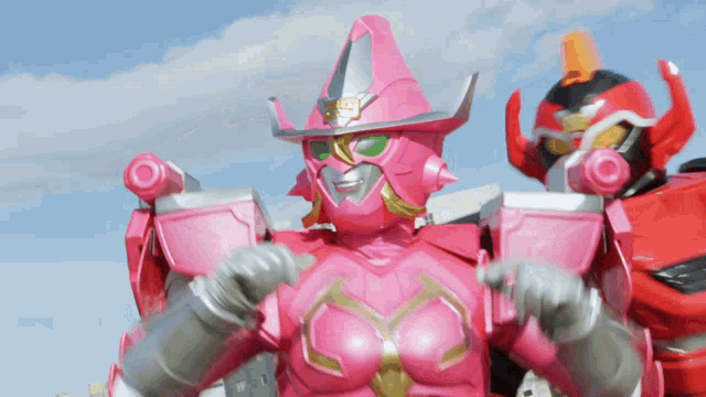 a pink robot with a cowboy hat on stands next to another robot