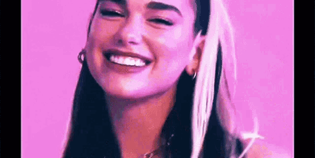 a close up of a woman 's face with a pink background and a smile on her face .