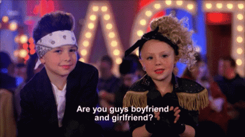 a boy and a girl are standing next to each other and the girl is asking the boy if he has a boyfriend